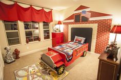 a bedroom decorated in red, white and blue with a firetruck themed bed