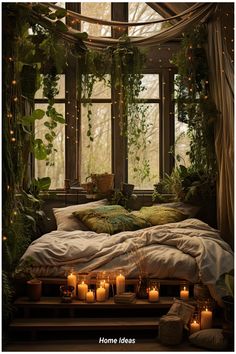 a bed with lots of candles on it in front of a window and some plants