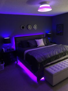 a bedroom with purple lighting and a large bed