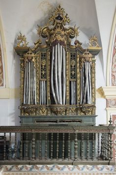 an ornate gold and green organ in a church