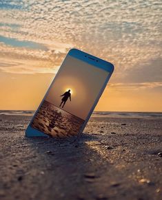 an image of a person walking on the beach with their cell phone in front of them