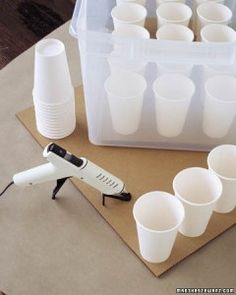 a table topped with white cups and a blow dryer on top of a cutting board