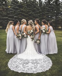 a group of bridesmaids standing in the grass