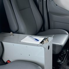 the back seat of a car with a desk and chair in it, next to an electronic device