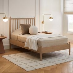 a bed sitting in a bedroom on top of a hard wood floor next to a window