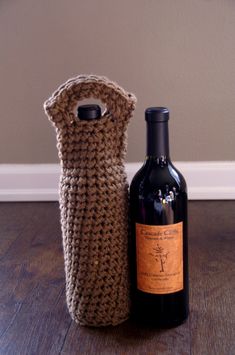 a bottle of wine next to a crocheted bag