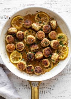 a white bowl filled with lemons and meatballs