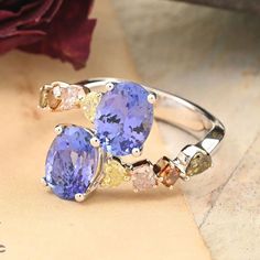 three different colored stones on a silver ring