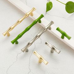 three metal handles with green stems on them