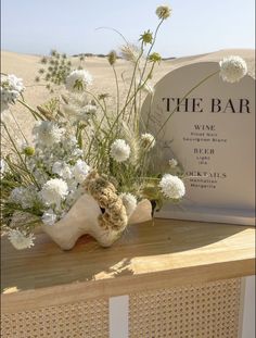 the bar sign and flowers are on display in front of an old bone - head