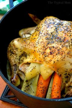 a roasting pan filled with chicken, carrots and celery