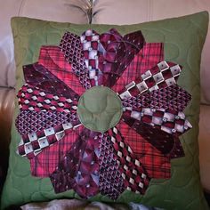 a green pillow with red and black designs on it