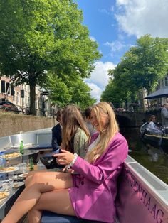 two women are sitting on a boat in the water