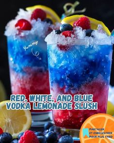 two glasses filled with red, white and blue vodka lemonade slush next to fruit