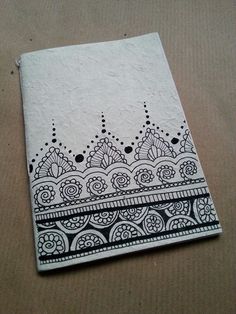 a piece of paper with black and white designs on the front, sitting on top of a table