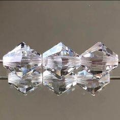 three crystal cubes sitting on top of a reflective surface