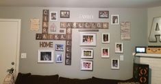 a living room filled with lots of pictures on the wall above a couch and fire place