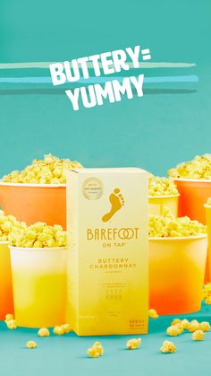 three yellow cups filled with popcorn next to a box of buttery - yummy