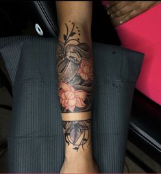 a woman's arm with tattoos on it and flowers in the middle of her leg