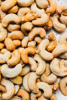 cashews are sitting on a white plate and ready to be eaten for consumption