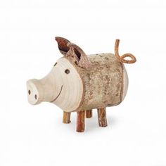 a small wooden toy pig sitting on top of a white floor next to a wall