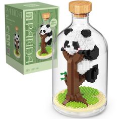 a glass bottle with a panda bear in it sitting next to a cardboard box and a lego model