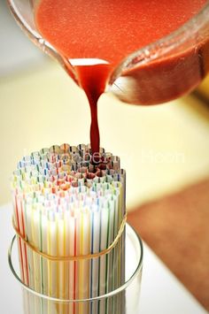 a glass filled with lots of different colored straws