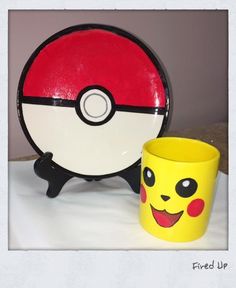 a yellow cup sitting next to a pokemon poke ball