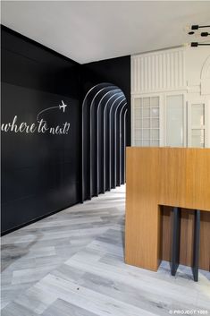 an office lobby with black walls and wooden floors