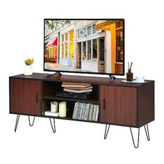 a flat screen tv sitting on top of a wooden entertainment center with hairpin legs