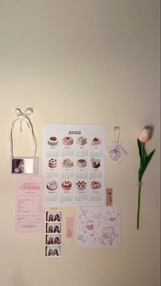 a white wall with pictures and magnets on it, including a pink tulip