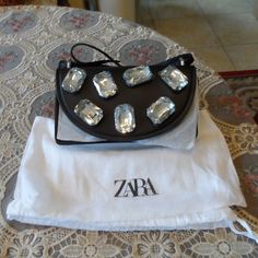 This Zara Bag Has A Structured Accordion Silhouette With Ample Space For Your Essentials. It's Been Made From Smooth Black Faux Leather And Punctuated On The Front Flap With Lustrous Shiny Faux Super Large Crystal Jewels The Faux Leather Strap Is Adjustable, So You Can Either Wear It Over Your Shoulder Or Cross-Body. Measures: 8"W X 5"H X 3"D. Comes With A Dust Bag. New With Tags Attached. No Scuffs, Stains. Comes From A Smoke Free Home. Designer Evening Shoulder Bag With Phone Holder, Zara Evening Shoulder Bag, Trendy Zara Bag For Party, Trendy Zara Party Bag, Zara Pouch Shoulder Bag For Evening, Zara Crossbody Party Bag, Zara Evening Bag With Removable Pouch, Zara Crossbody Bag For Party, Zara Evening Bag With Top Handle