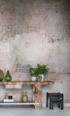 three vases are sitting on top of a wooden table in front of a brick wall