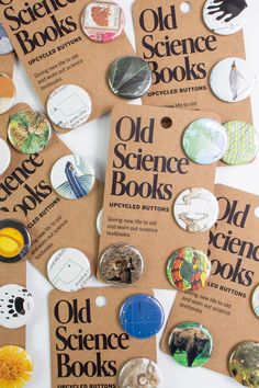 several old science books are shown with buttons on the back and in brown paper tags attached to them