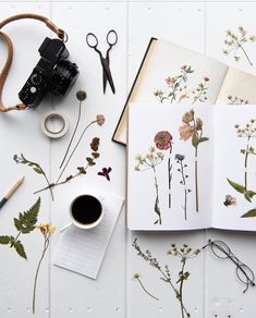 an open book sitting on top of a white table next to scissors and other items