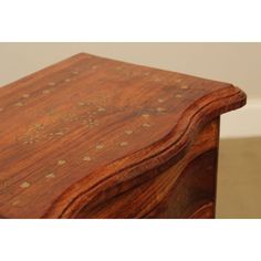 an old wooden box with gold leaf designs on the lid and bottom, sitting on a table