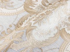 close up view of gold and white wallpaper with intricate designs on it's surface