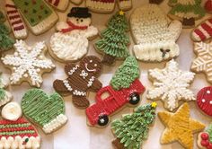 decorated cookies are arranged in rows on a table with snowflakes, mittens and christmas trees