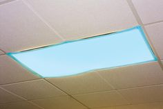 the ceiling in an office building is painted white and has blue light coming from it