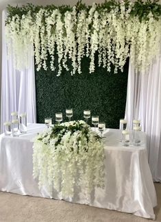 the table is set up with white flowers and wine glasses for an elegant wedding reception