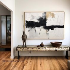 an abstract painting hangs on the wall above a bench with two bowls and a statue