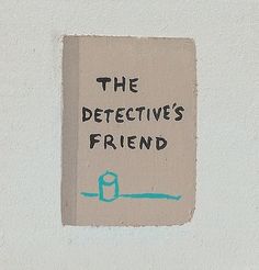 a piece of paper with the words the detective's friend written on it is attached to a wall