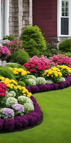 colorful flowers line the lawn in front of a house