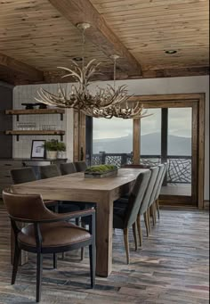 a dining room table with chairs and a chandelier hanging from it's ceiling