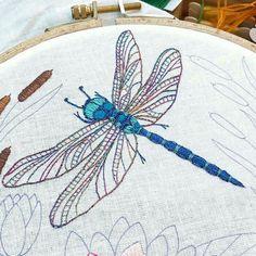 a blue dragonfly sitting on top of a wooden hoop