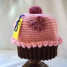 a knitted cupcake hat on top of a wooden stand with a price tag