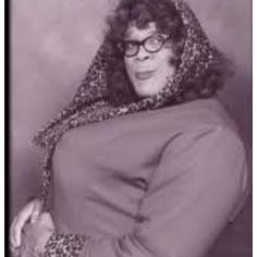 an old photo of a woman wearing glasses and a leopard print scarf over her head