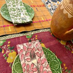 a table topped with plates and napkins next to a vase