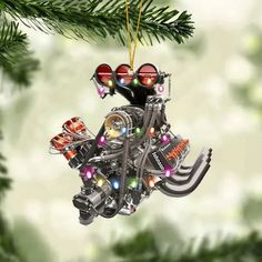 a motorcycle engine ornament hanging from a christmas tree with lights and ornaments on it