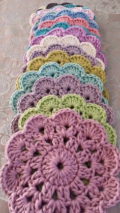 there are many crocheted doilys on the table together, all in different colors